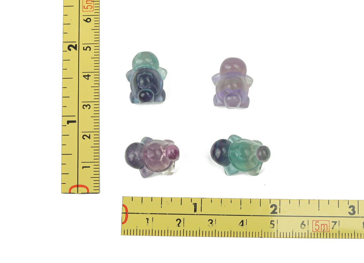 Fluorite tortoise gemstone carving from GemstoneGO, detailed green and purple mineral sculpture on a neutral background.