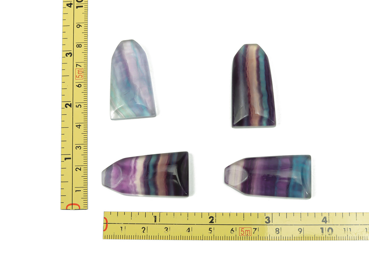 Fluorite flat tower carving gemstone from GemstoneGO showcasing vibrant purple and green hues, polished and detailed for display.