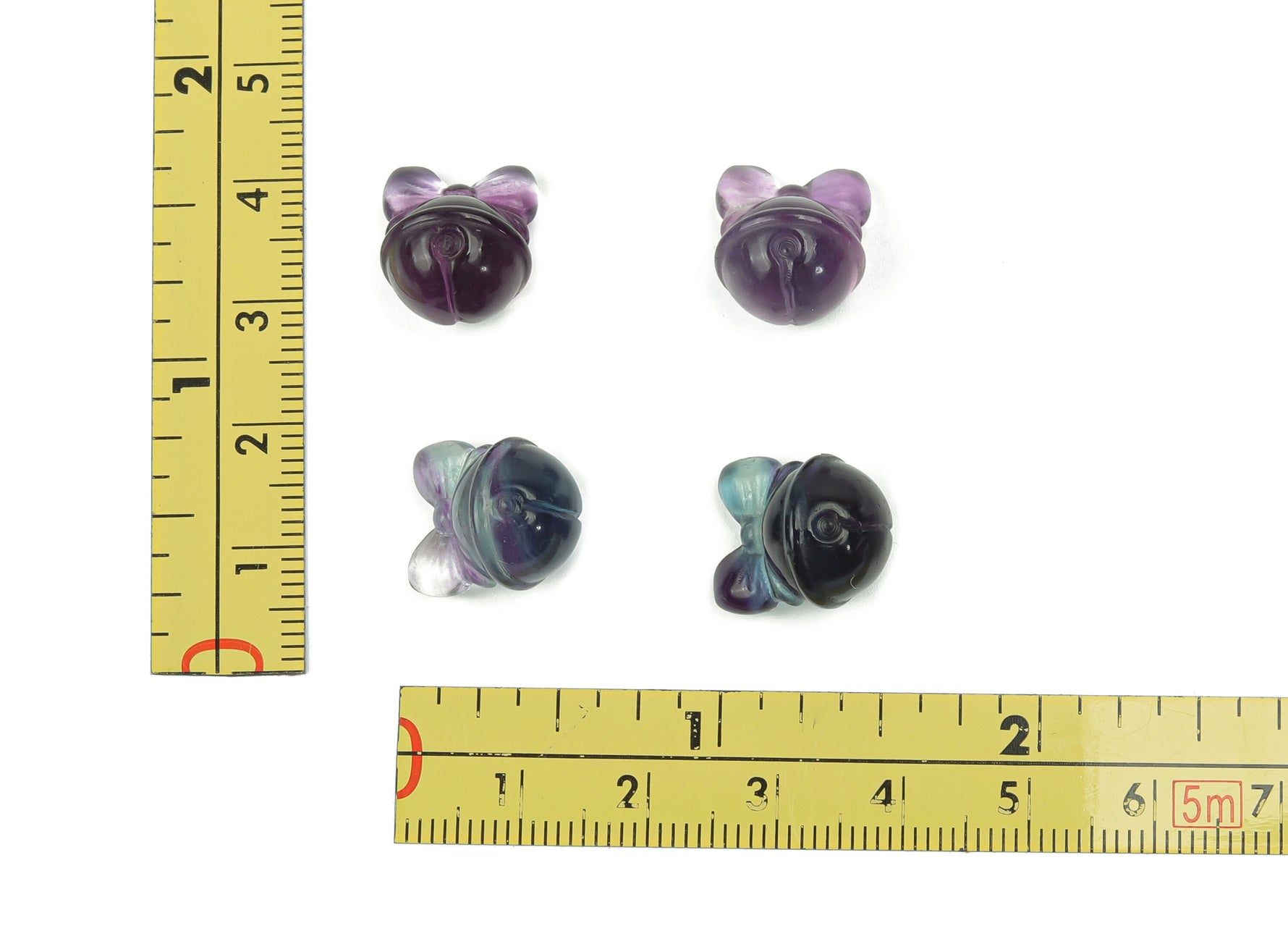 Polished fluorite crystal gemstone carving with vibrant purple and green hues, showcasing intricate natural patterns and smooth finish.
