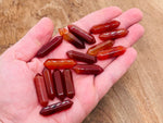 Carnelian terminated carved point gemstone from GemstoneGO, 33mm, featuring rich orange-red color and smooth polished surface.