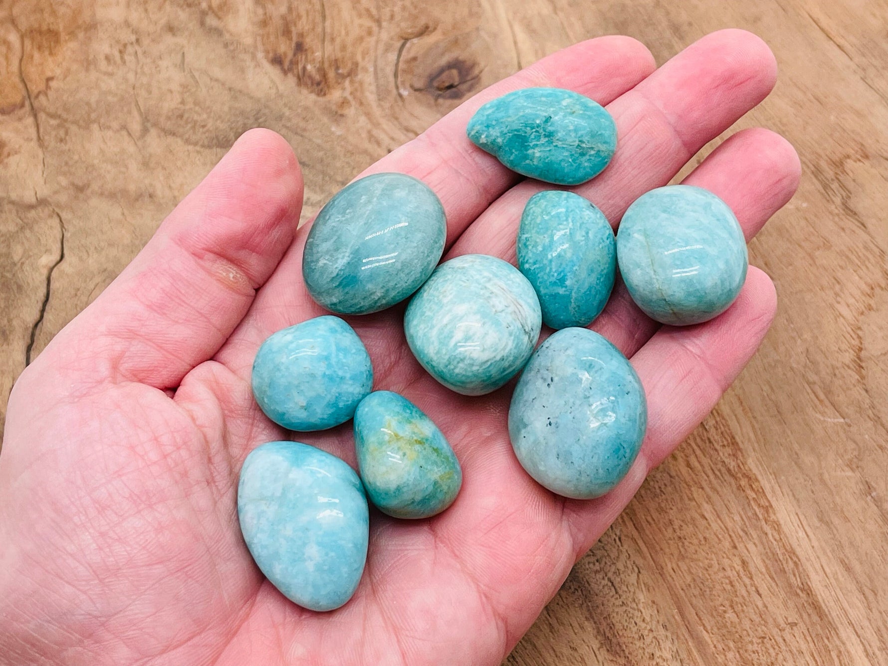 Polished Amazonite tumbled stone from GemstoneGO, smooth blue-green mineral with natural patterns and a glossy finish.