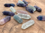 33mm fluorite terminated carved point gemstone from GemstoneGO, showcasing vibrant green and purple mineral layers.