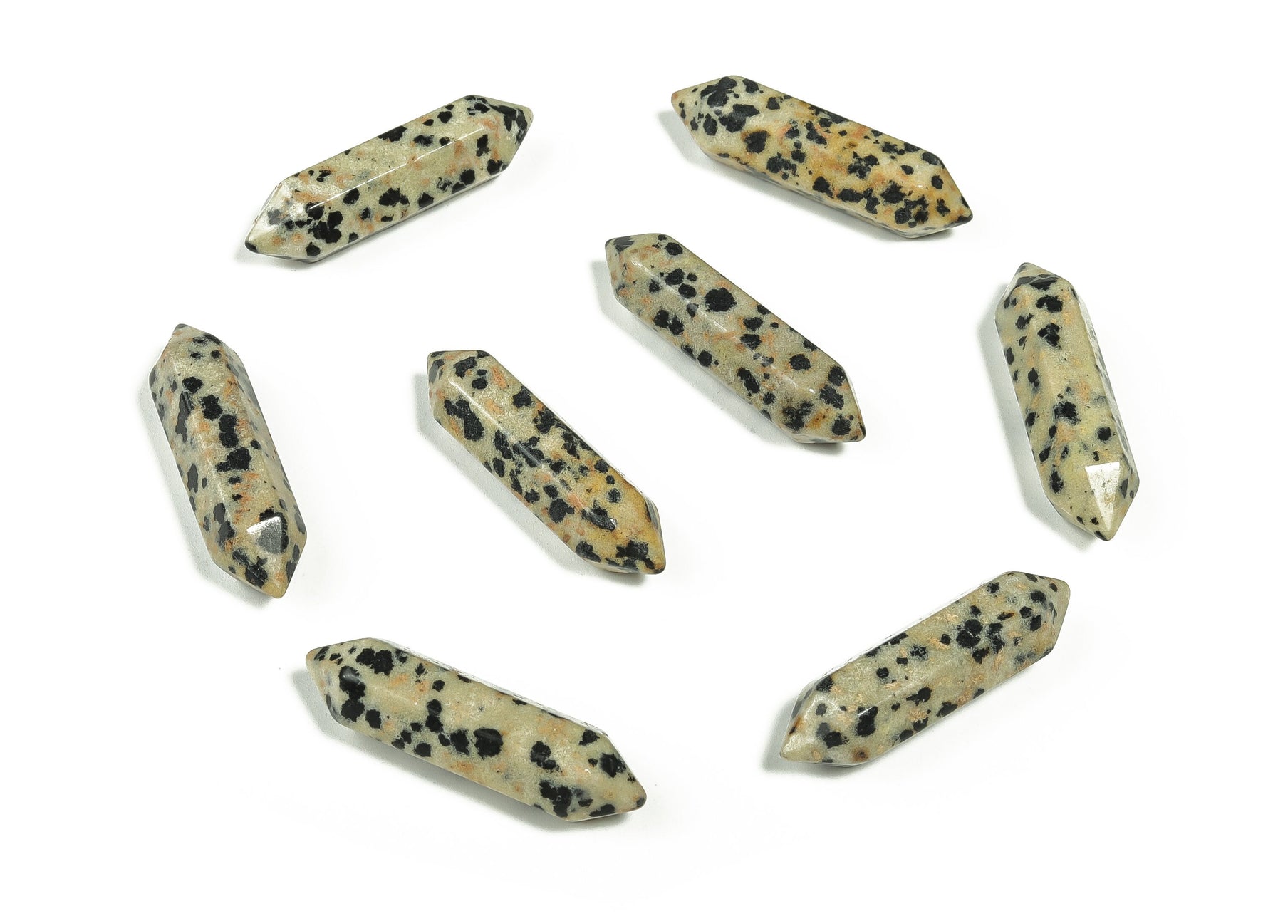 Dalmatian Jasper terminated carved point gemstone from GemstoneGO, 33mm, showcasing black spots on a cream-colored stone.