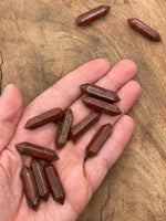 Red sesame terminated carved point gemstone from GemstoneGO, 33mm length, featuring intricate carving and vibrant red color.