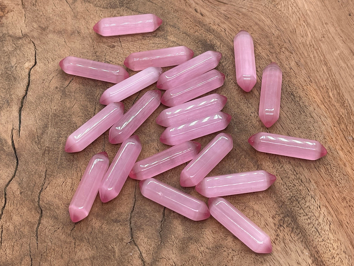 Pink Cats Eye gemstone carved point, 33mm, from GemstoneGO, showing polished carved stone with a pink cat's eye effect.