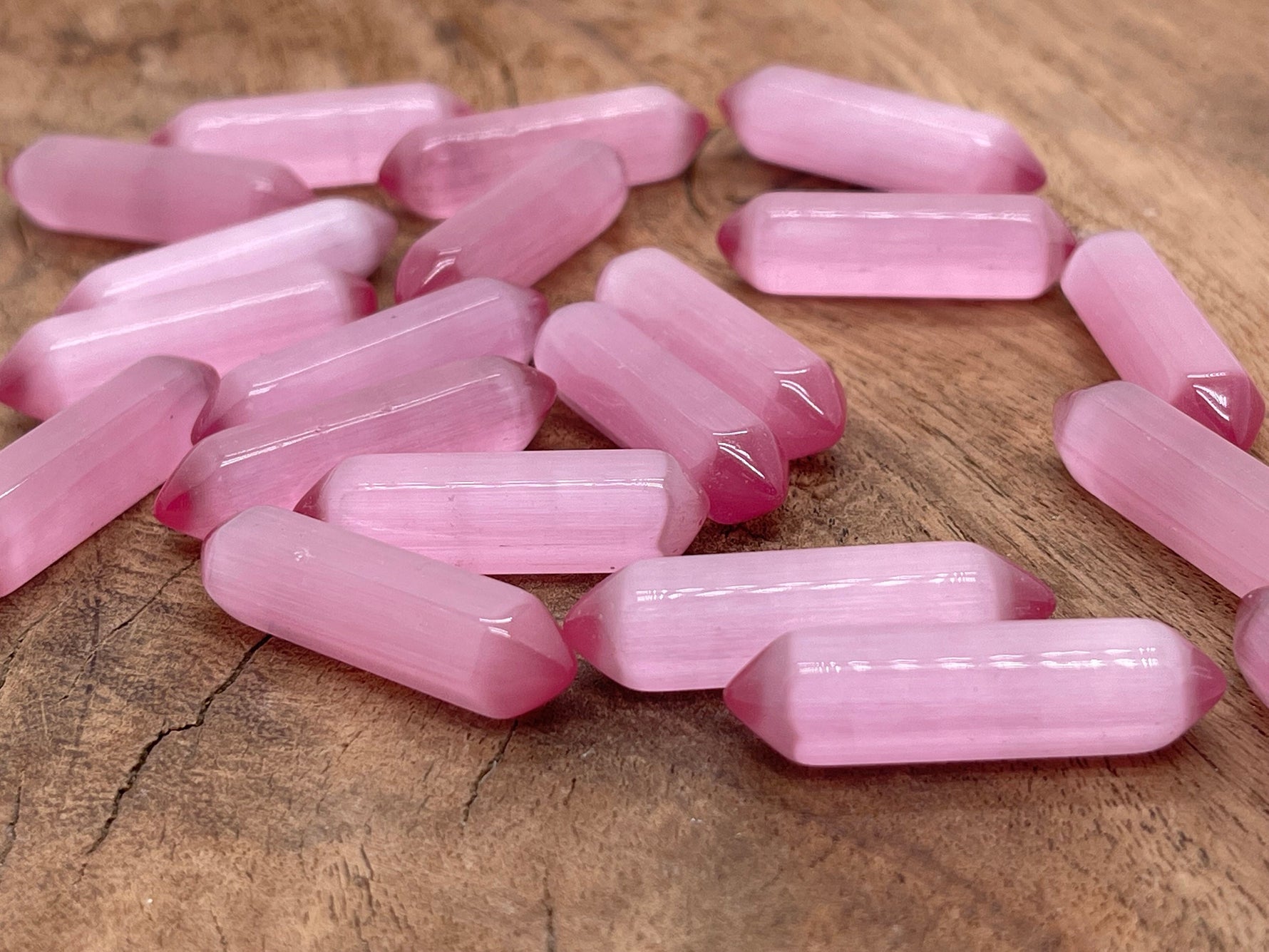 Pink Cats Eye gemstone carved point, 33mm, from GemstoneGO showcasing a polished, carved cabochon with vibrant pink and chatoyancy.