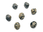 Dalmatian Jasper Saturn crystal carved as a mini planet gemstone, 18mm, showcasing black spots on a cream background.