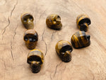 Carved Tiger Eye skull gemstone, 25mm, with detailed features and rich golden-brown color, by GemstoneGO.