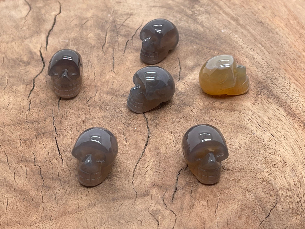 Grey Agate Skull carved gemstone, 25mm, showing detailed skull with natural stone patterns and a polished finish.