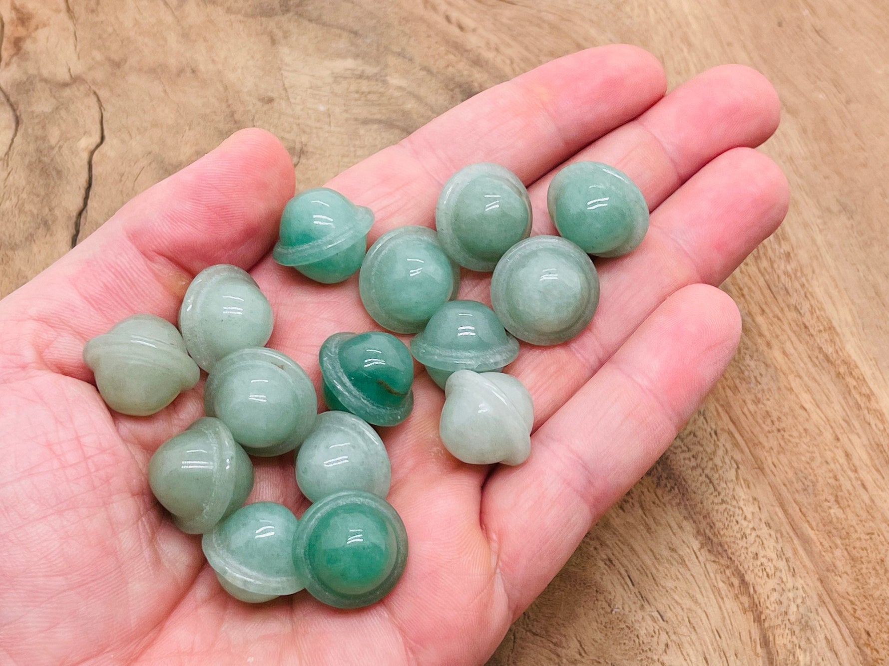 A small 18mm carved aventurine Saturn gemstone planet, detailed with natural green hues, displayed on a plain background.