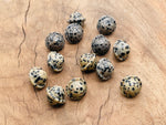 Dalmatian Jasper Saturn crystal carved as a mini planetary gemstone, 18mm, showcasing black spots on cream-colored stone.