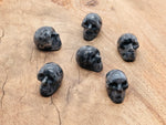Larvikite skull carved gemstone, 25mm, with polished dark gray and blue iridescent surface, from GemstoneGO.