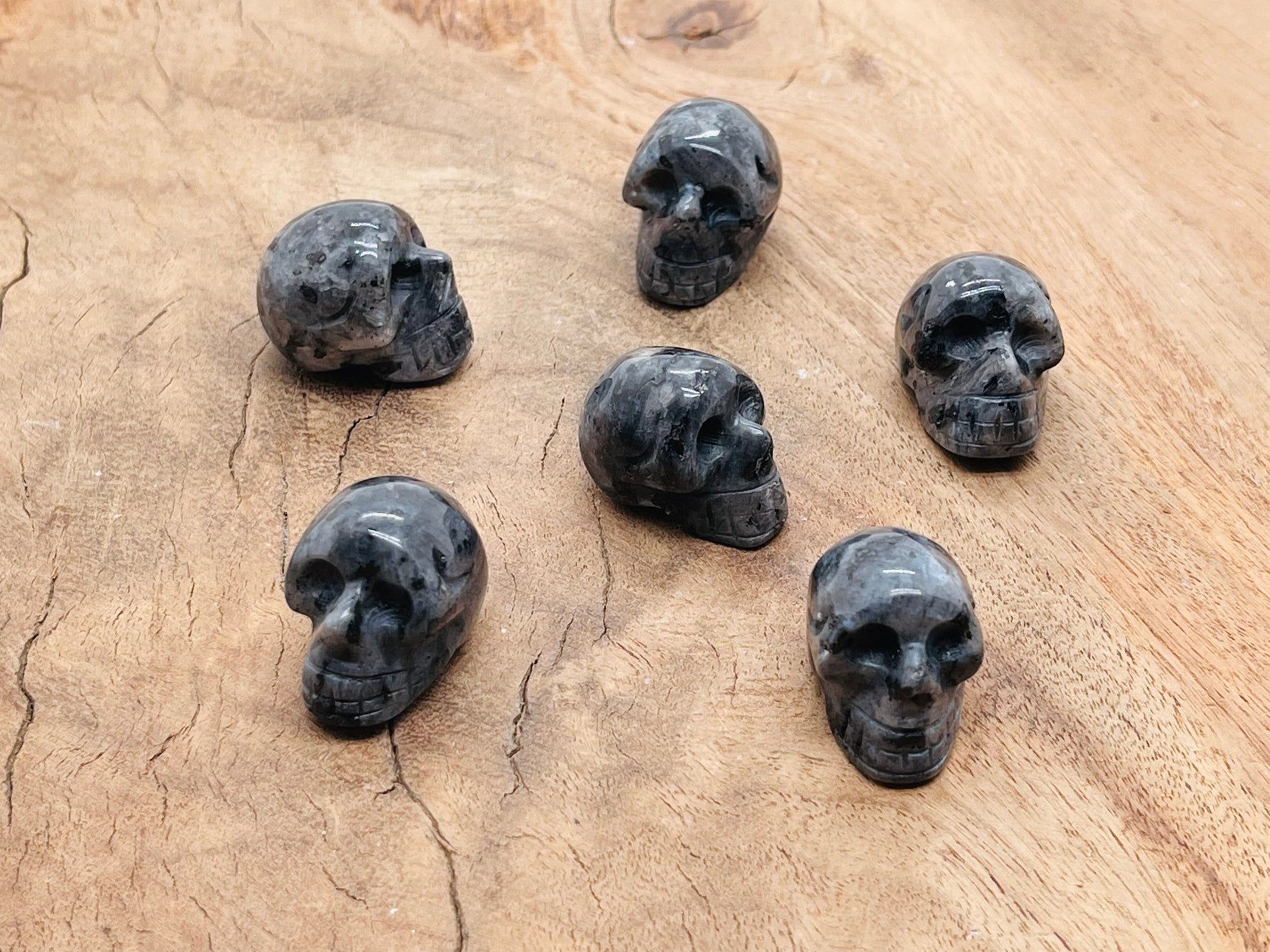 Larvikite skull carved gemstone, 25mm, with polished dark gray and blue iridescent surface, from GemstoneGO.