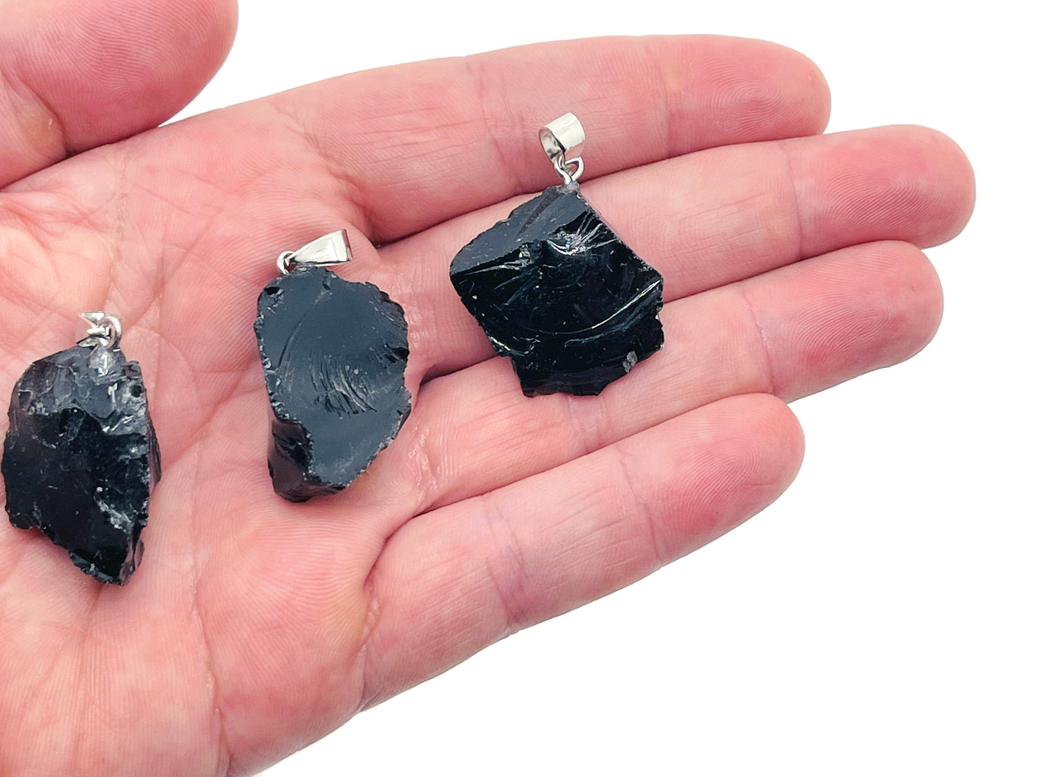 Obsidian crystal pendant on a silver chain, showcasing a polished black gemstone with natural veining, from GemstoneGO.