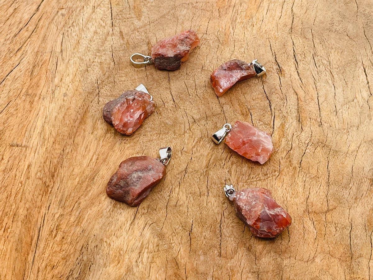 Carnelian crystal pendant with polished oval shape and silver-tone bail from GemstoneGO, showcasing vibrant orange gemstone.