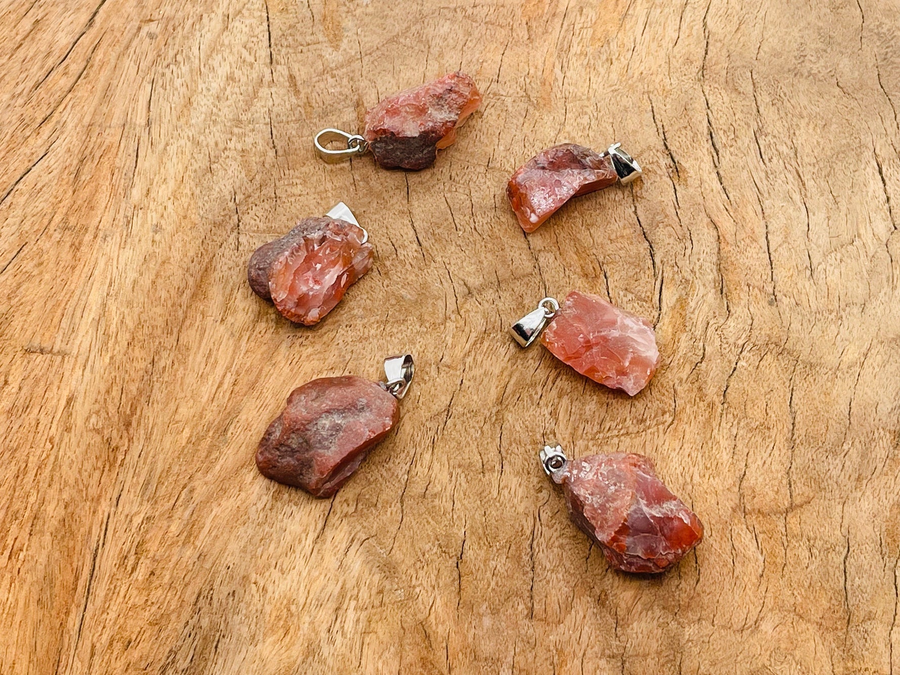 Carnelian crystal pendant with polished oval shape and silver-tone bail from GemstoneGO, showcasing vibrant orange gemstone.