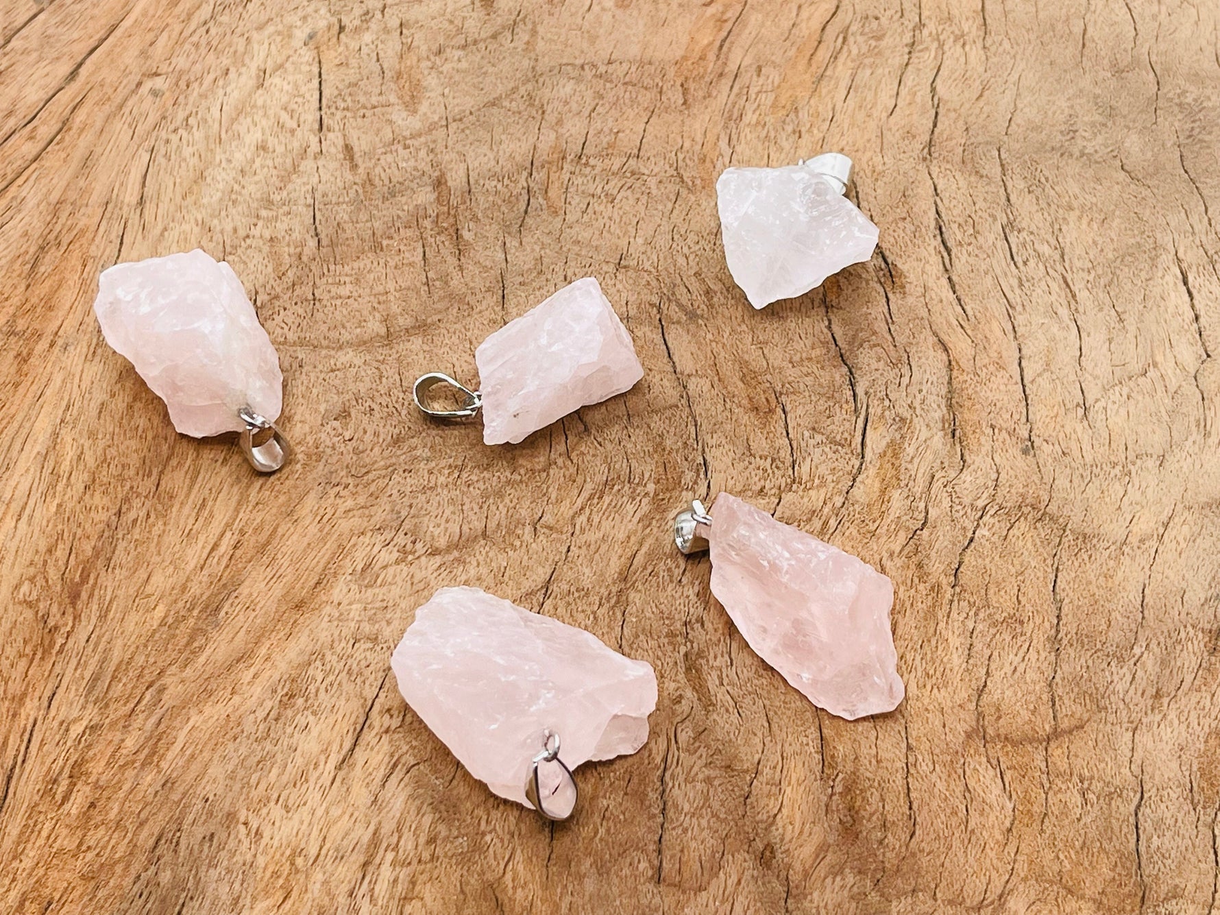 Rose quartz crystal pendant from GemstoneGO featuring a polished teardrop shape and silver-tone bail.