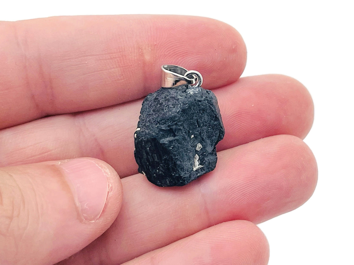 Black Tourmaline crystal pendant from GemstoneGO featuring a polished black stone with silver bail on a chain.