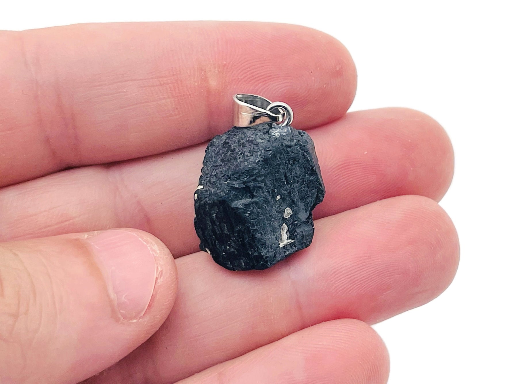 Black Tourmaline crystal pendant from GemstoneGO featuring a polished black stone with silver bail on a chain.