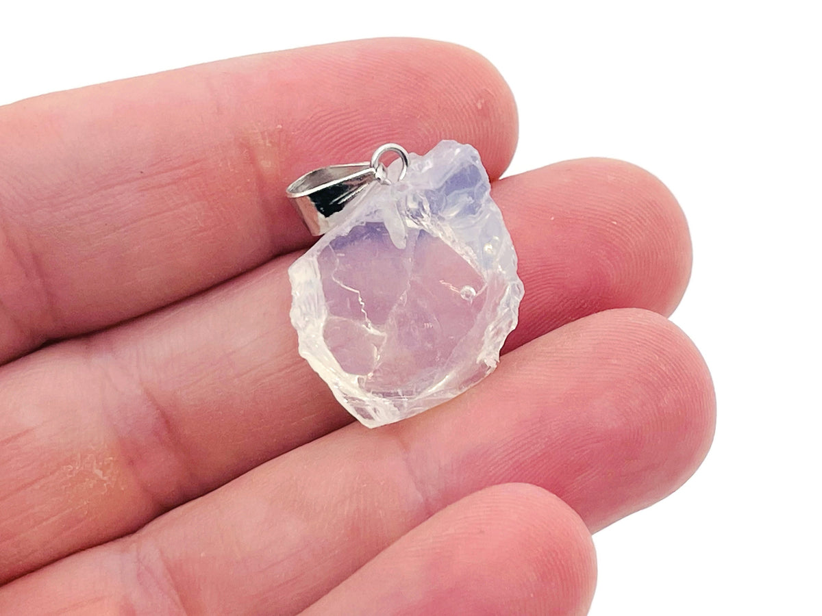 Opalite crystal pendant from GemstoneGO hanging on a silver chain, showcasing its smooth, glowing oval shape.