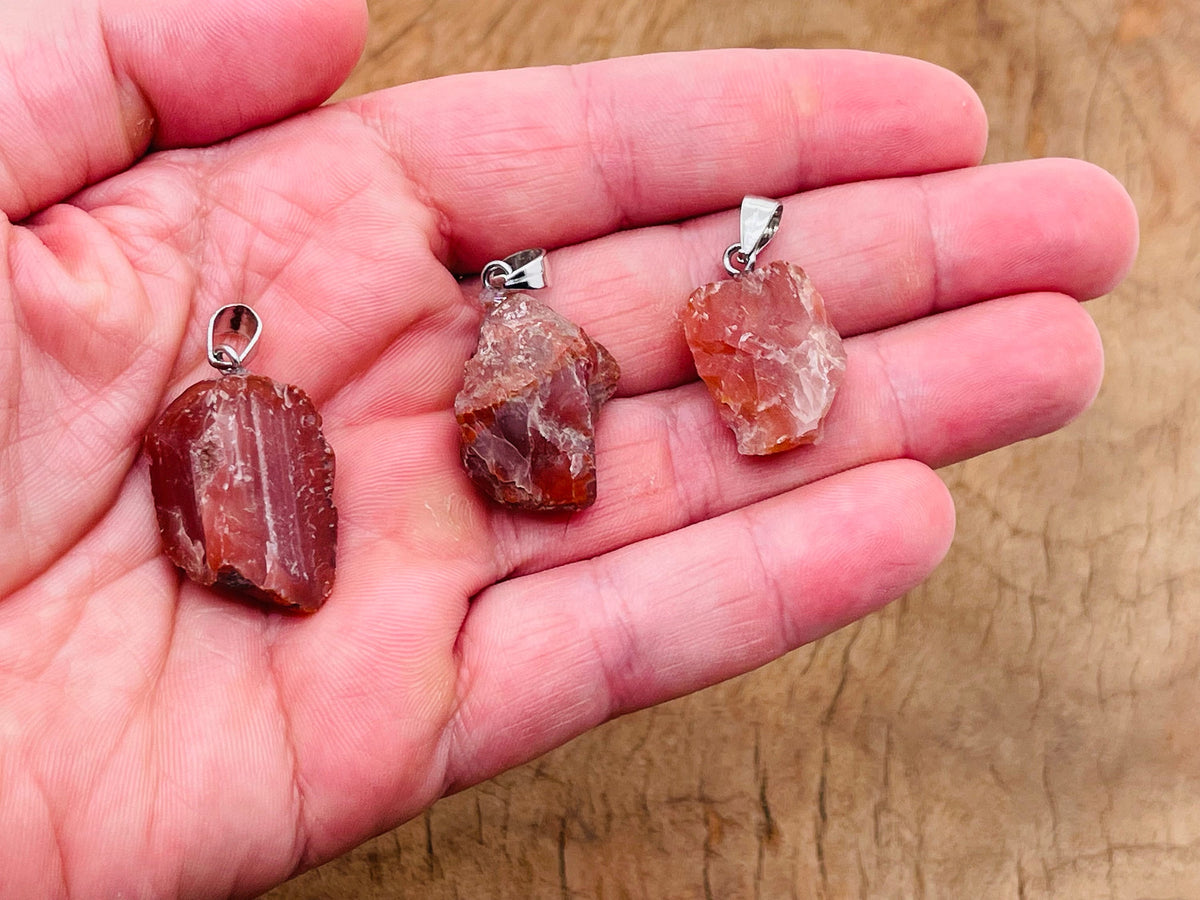 Carnelian crystal pendant featuring a polished orange gemstone on a silver chain, crafted by GemstoneGO.
