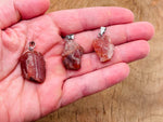 Carnelian crystal pendant featuring a polished orange gemstone on a silver chain, crafted by GemstoneGO.