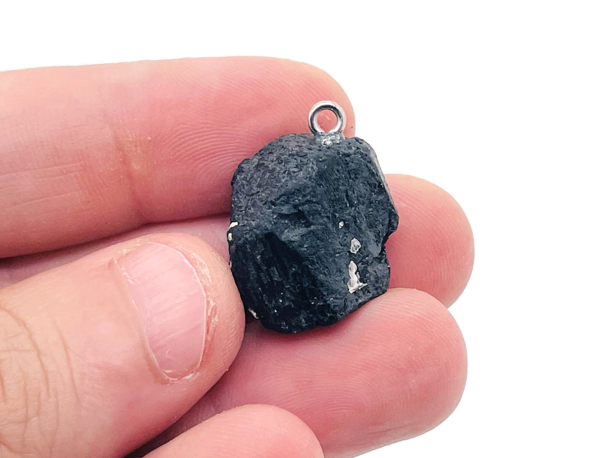 Black Tourmaline crystal pendant from GemstoneGO featuring a polished black stone on a silver chain.