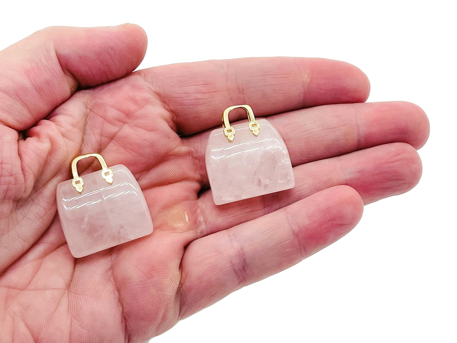 Rose quartz crystal handbag pendant with carved gemstone detail, featuring a smooth, polished surface and a loop for hanging.
