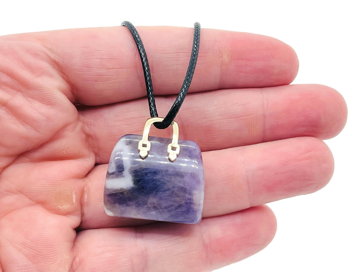 Amethyst crystal carved handbag pendant with detailed gemstone carving, showcasing purple amethyst gemstone jewelry.