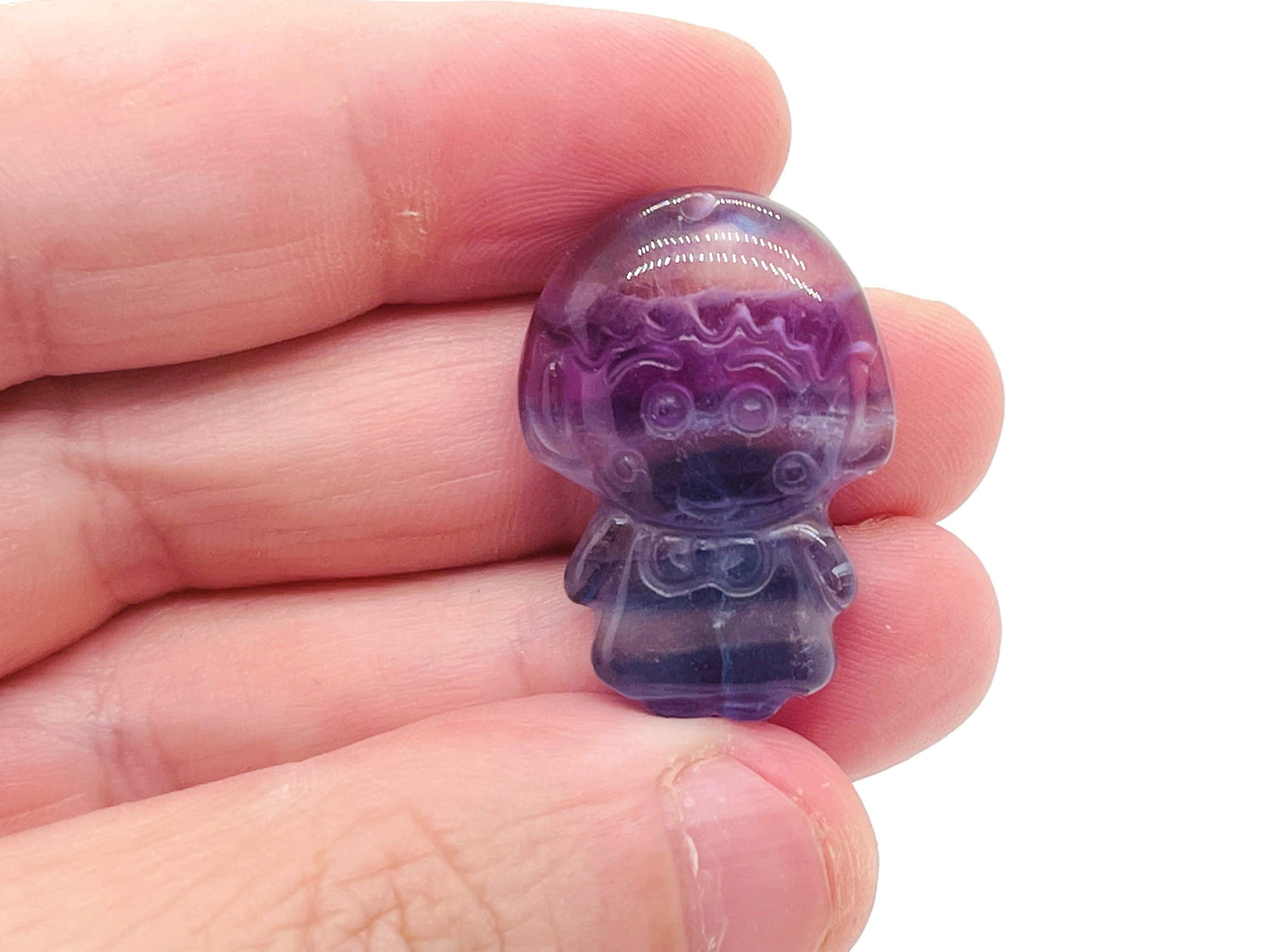 Fluorite girl kid carving gemstone from GemstoneGO showing a colorful carved figurine on a smooth surface.