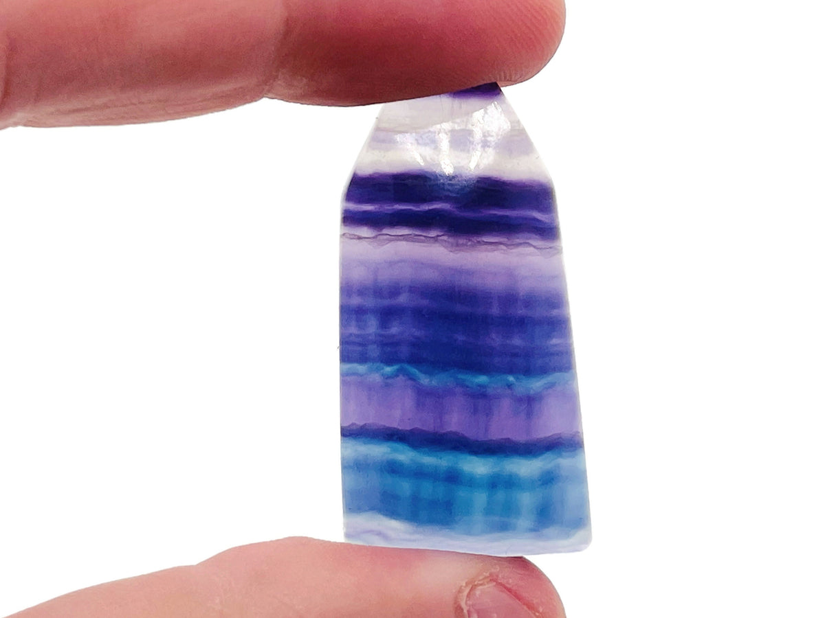 Fluorite flat tower carving gemstone from GemstoneGO, showcasing vibrant purple and green hues with smooth polished surfaces.