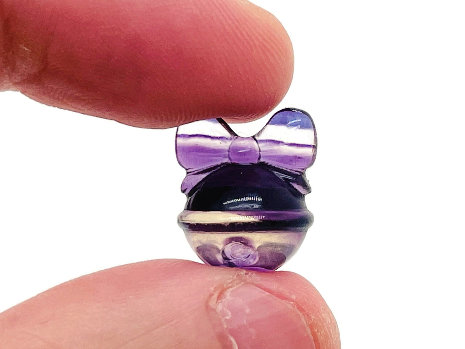 Fluorite crystal carving gemstone from GemstoneGO, vibrant purple and green hues with intricate natural patterns.