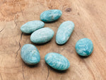 Amazonite palm gemstone spa stone from GemstoneGO, showcasing a smooth, polished blue-green stone for relaxation and healing.