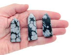 Snowflake Obsidian obelisk tower crystal by GemstoneGO, showcasing black volcanic glass with white snowflake-like mineral patterns.