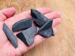 Raw Shungite gemstone from GemstoneGO showing a dark, textured mineral specimen with natural rough surface and irregular shape.