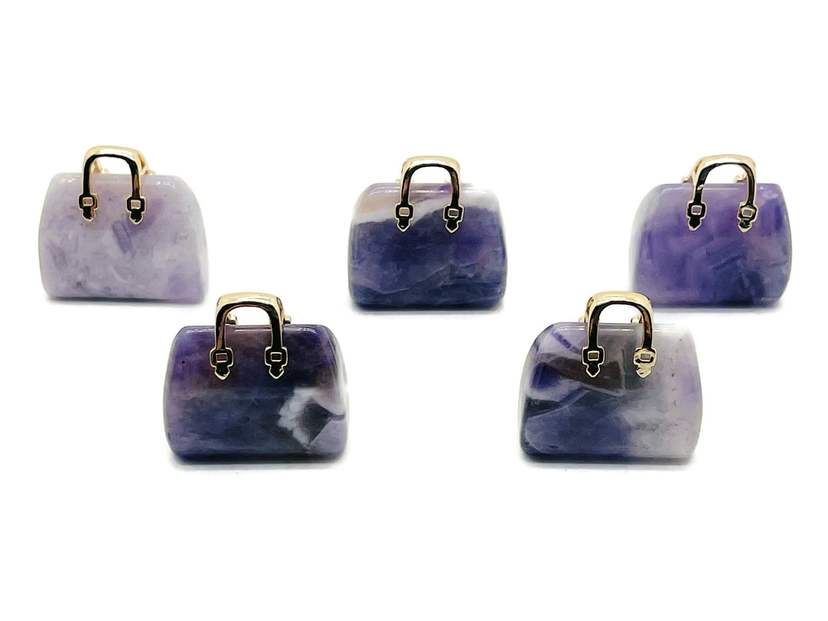 Amethyst crystal handbag pendant featuring a carved gemstone in a purse shape, hanging on a silver chain.