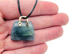 Labradorite crystal purse carving gemstone pendant with intricate handbag design, showcasing vibrant labradorite iridescence.
