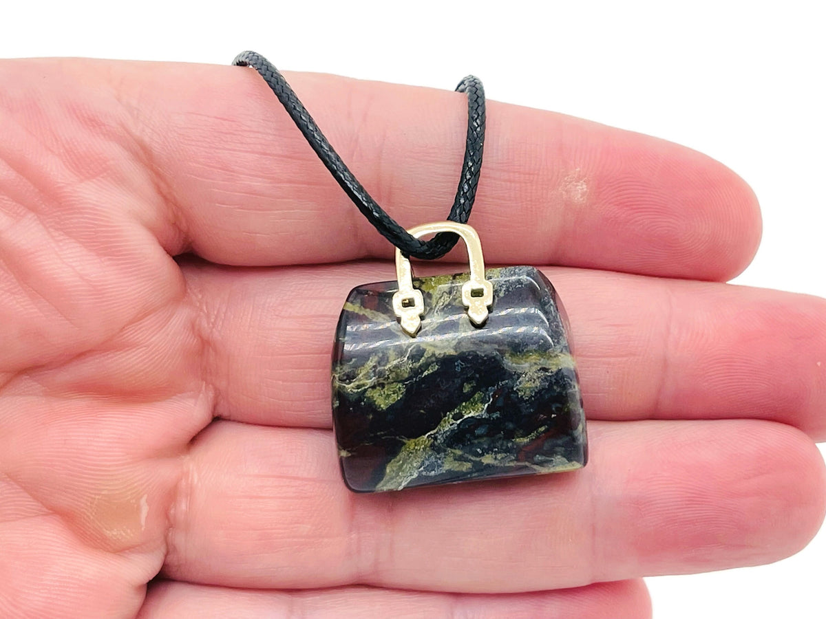 Dragon Blood Jasper gemstone pendant featuring a carved crystal handbag design, ideal for jewelry or decorative collection.