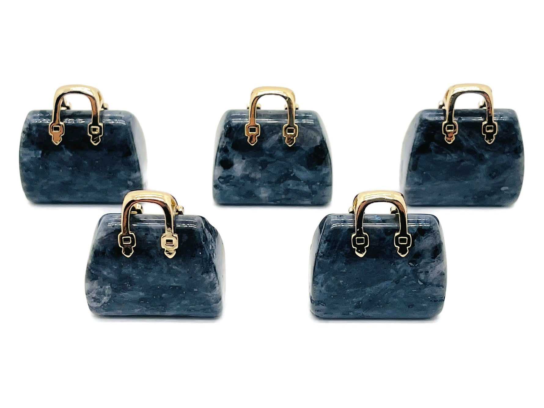 Larvikite crystal purse carving gemstone used as a handbag pendant, showcasing detailed craftsmanship and natural stone patterns.