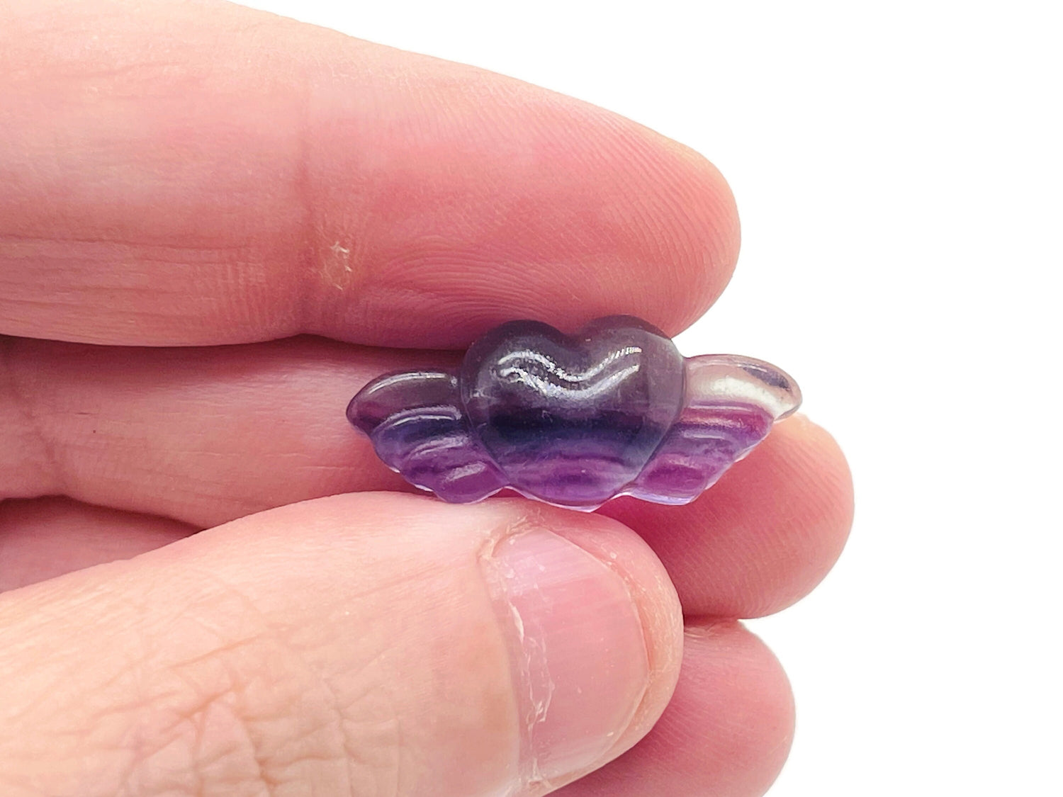Fluorite wing heart gemstone carving from GemstoneGO, showing vibrant green and purple hues with detailed wing and heart design.