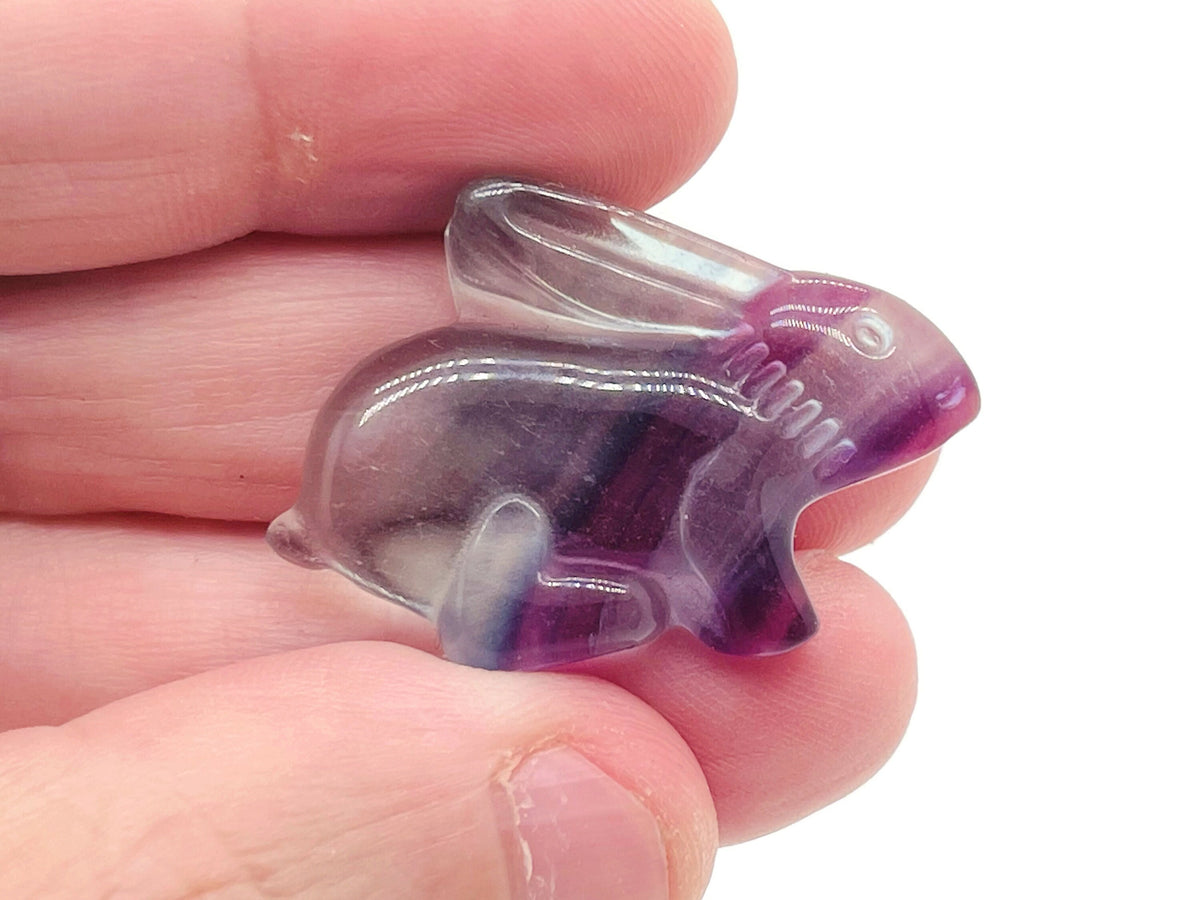Fluorite rabbit gemstone carving from GemstoneGO, showing a colorful, polished rabbit figurine with vibrant purple and green hues.