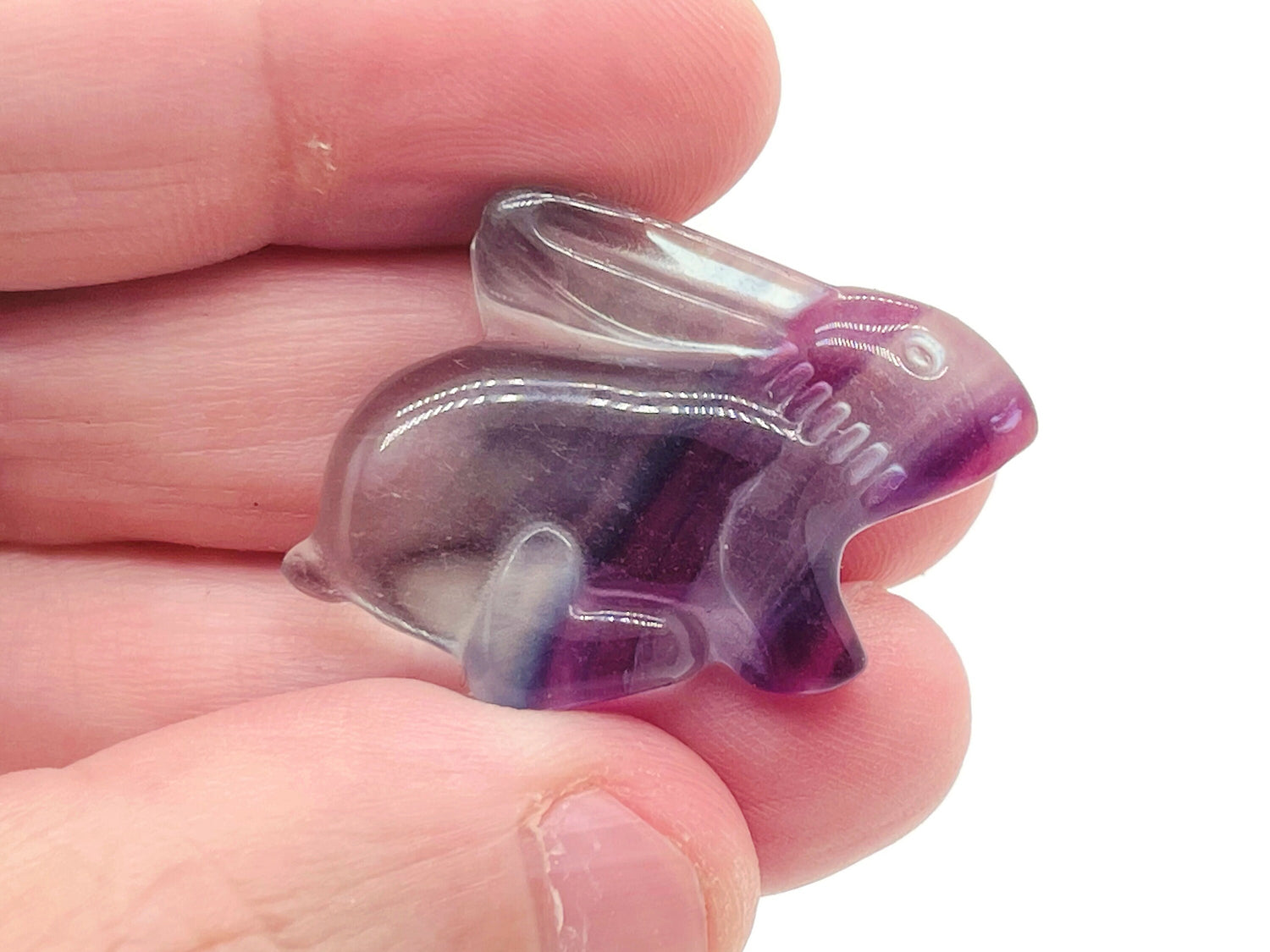 Fluorite rabbit gemstone carving from GemstoneGO, showing a colorful, polished rabbit figurine with vibrant purple and green hues.