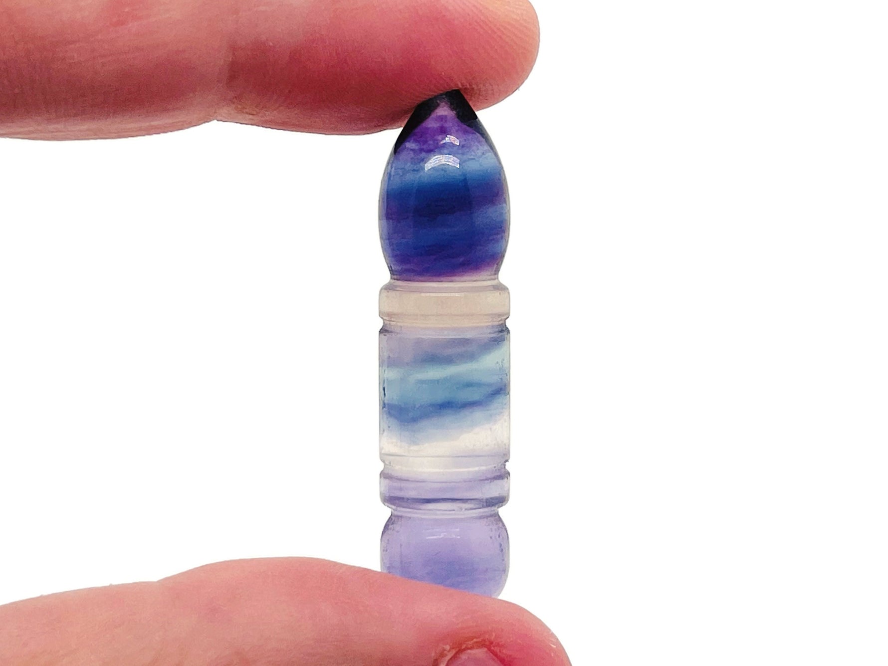 Polished fluorite bullet-shaped gemstone from GemstoneGO, showcasing vibrant green and purple hues with smooth surface detailing.