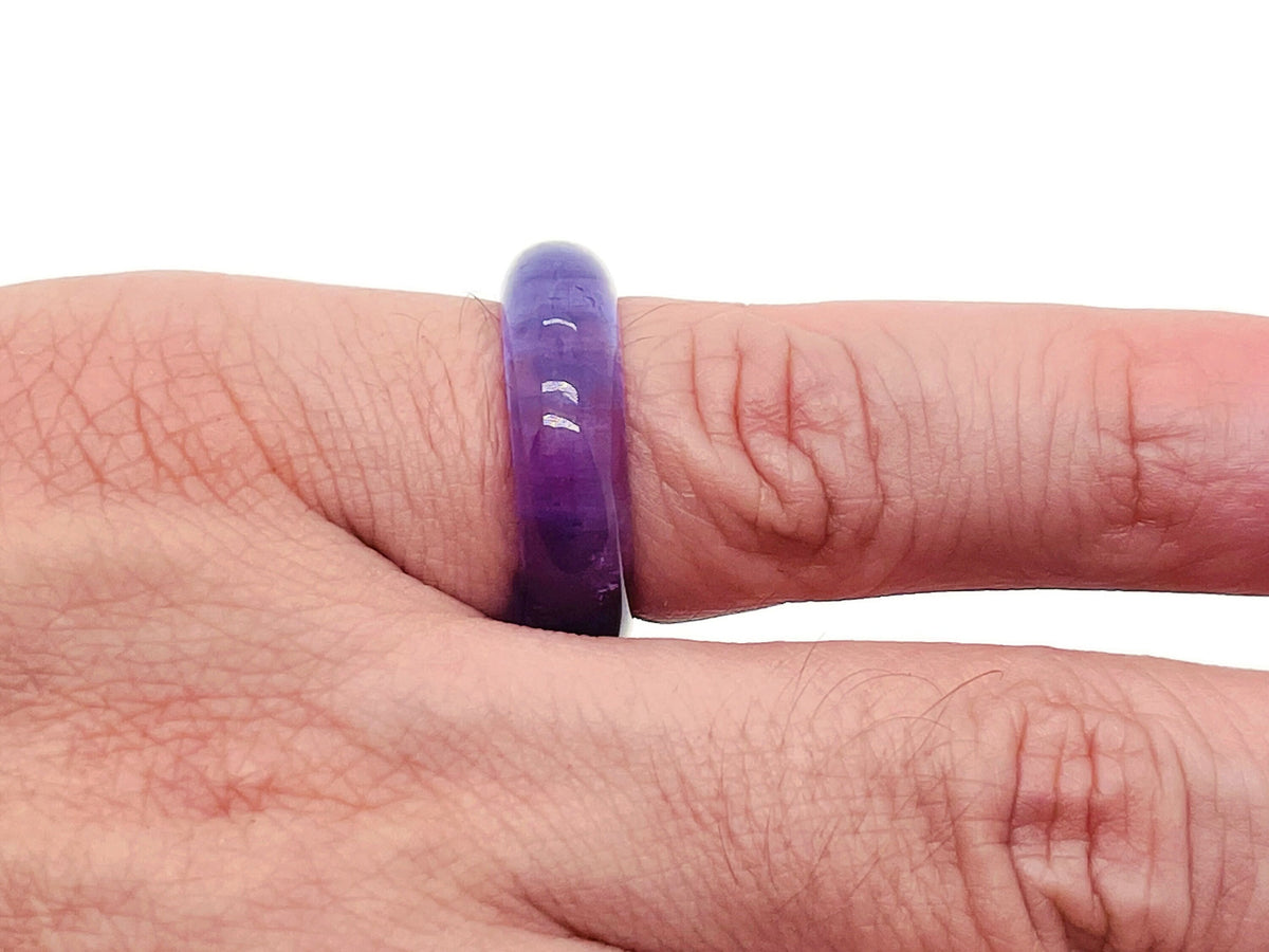 Amethyst crystal ring by GemstoneGO featuring a large purple gemstone set in a silver band, close-up view of the jewelry.