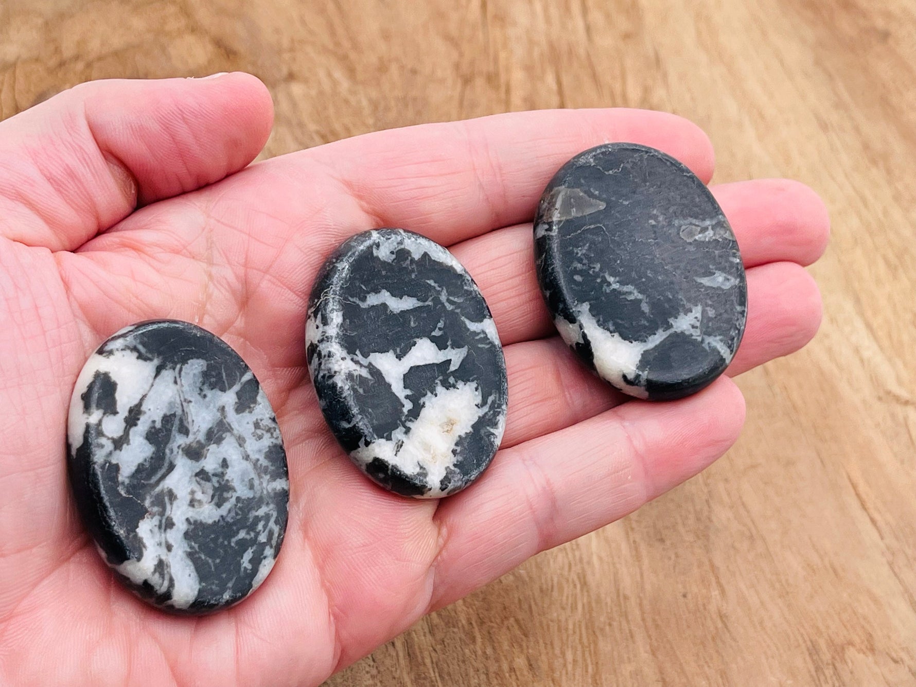 Zebra Calcite worry stone from GemstoneGO, smooth 4.5x3.5cm crystal with black and white striped pattern for soothing stress relief.