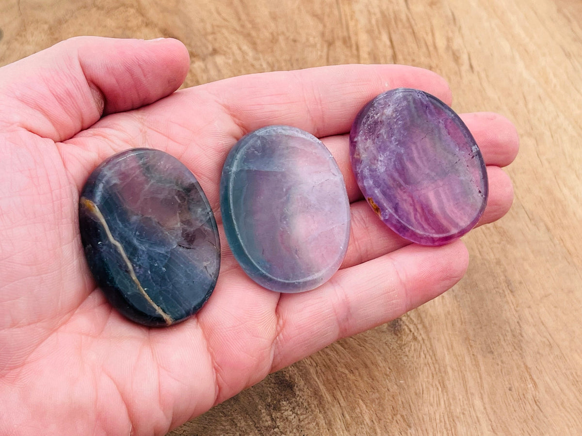 Smooth fluorite worry stone from GemstoneGO, measuring 4.5x3.5cm, featuring calming green and purple crystal hues.