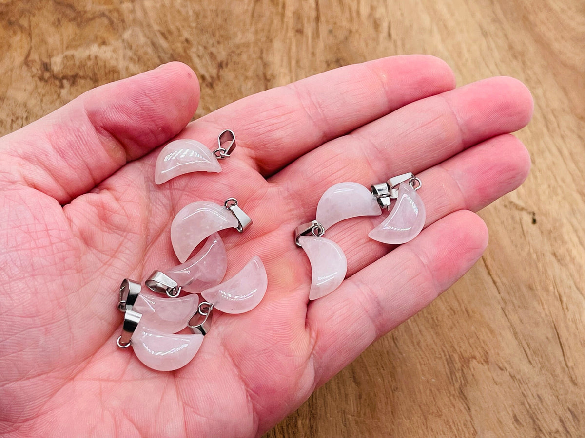 Rose quartz moon-shaped crystal pendant from GemstoneGO, ideal for jewelry making, showcasing a smooth, polished pink gemstone.