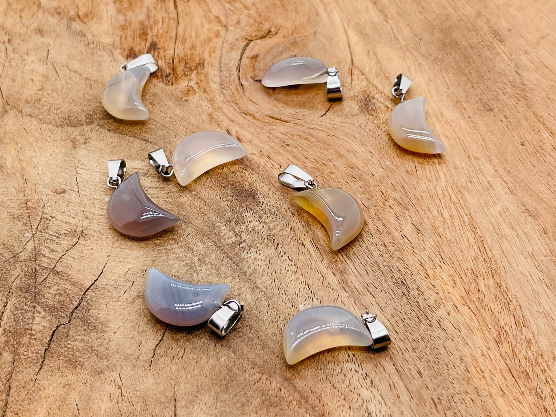 Grey agate moon crystal pendant from GemstoneGO featuring a polished moon shape, ideal for jewelry making supplies.