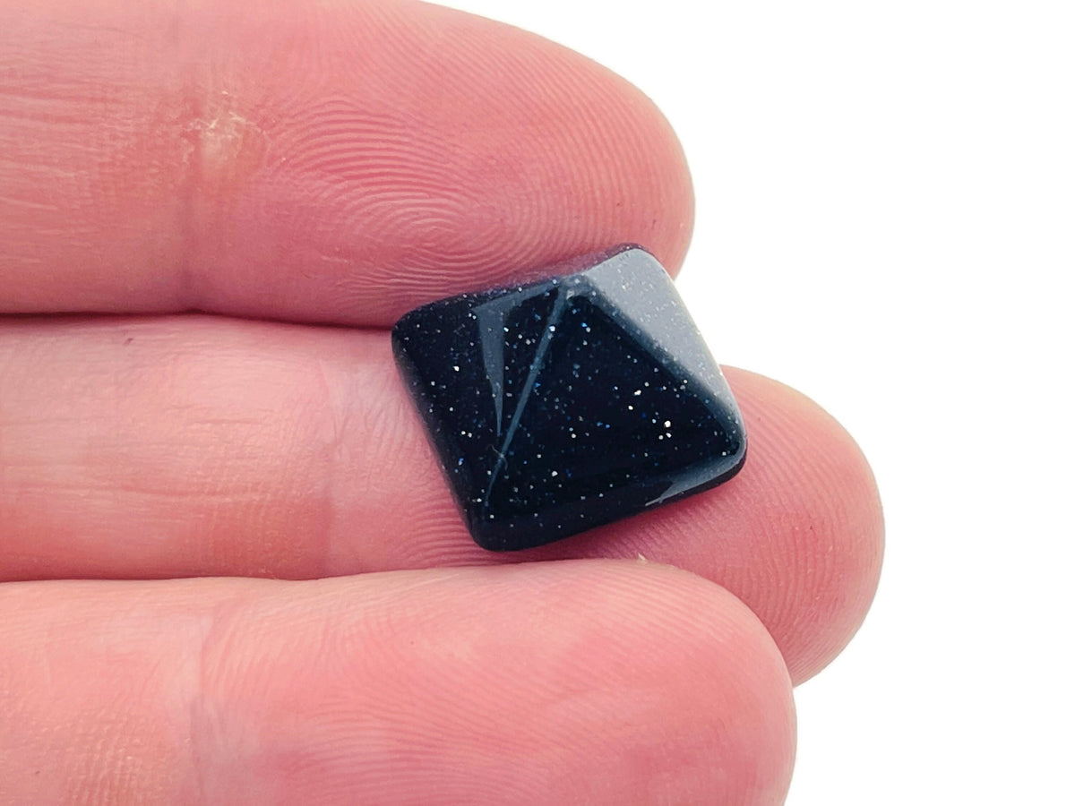 Blue Goldstone pyramid gemstone carving, 14mm, from GemstoneGO, showcasing a smooth, polished pyramid with sparkling gold flecks.