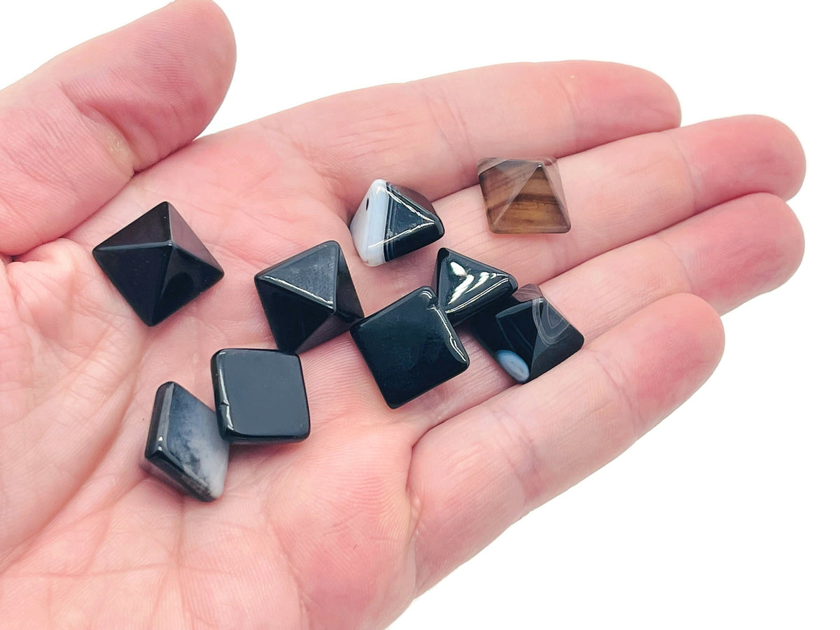 Black agate pyramid gemstone carving, 14mm, by GemstoneGO, showing a polished black agate pyramid with natural banding and smooth facets.